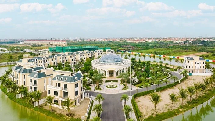 Toàn cảnh khu biệt thự và tòa nhà trung tâm hình tròn mái vòm kính, bao quanh bởi hồ nước và cây xanh
