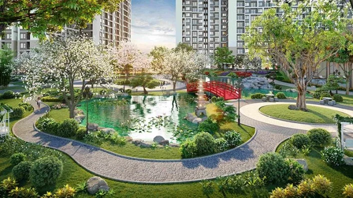 Hồ cảnh quan với cầu đỏ cong, cây xanh và đường dạo bộ trong vườn Nhật Bản