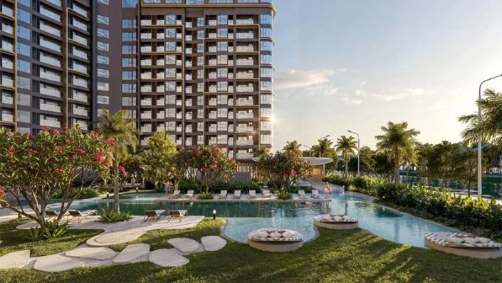 Hồ bơi phong cách resort với ghế thư giãn và cây xanh bao quanh, nằm cạnh tòa tháp chung cư