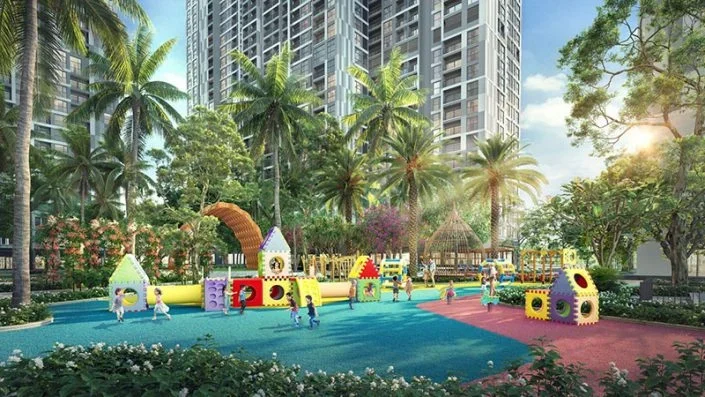 Sân chơi trẻ em đầy màu sắc với nhiều trò chơi vận động, có trẻ em đang vui chơi, bao quanh bởi cây xanh và tòa nhà cao tầng