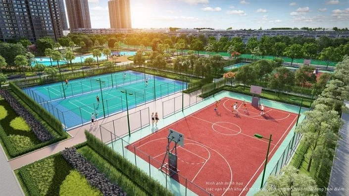 Toàn cảnh sân bóng rổ màu đỏ và sân tennis màu xanh dương ngoài trời, được bao quanh bởi cây xanh và các tòa nhà cao tầng