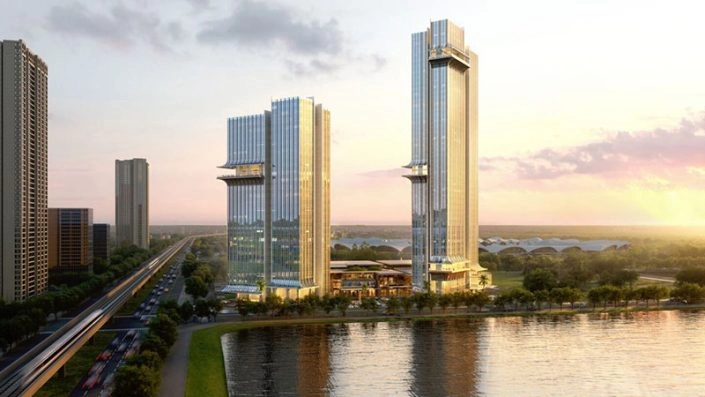 Hai tòa tháp cao tầng hiện đại với kiến trúc kính sang trọng bên bờ sông, cạnh đường giao thông và đường sắt.