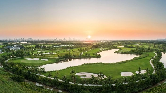 Toàn cảnh sân golf rộng lớn với hồ nước và cảnh hoàng hôn tuyệt đẹp
