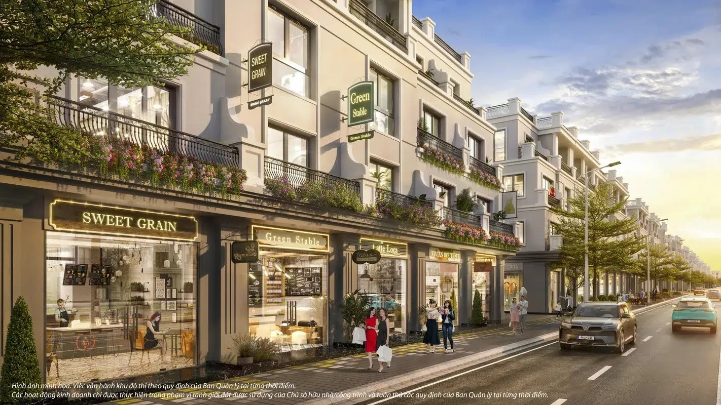 Góc nhìn cận cảnh dãy nhà phố thương mại với các cửa hàng đa dạng, người đi bộ và xe cộ trên đường