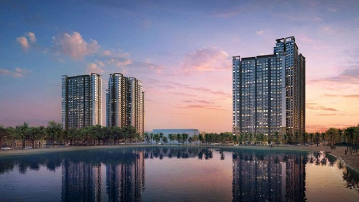 Hai tòa nhà chung cư cao tầng phản chiếu trên mặt hồ nước lúc hoàng hôn