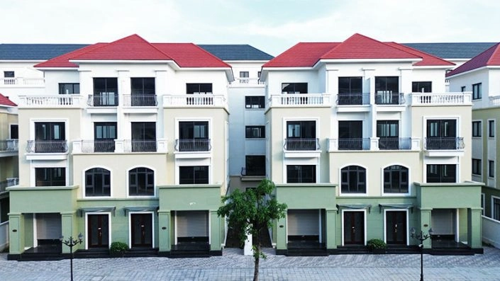 Mặt tiền dãy nhà phố liền kề sơn màu xanh nhạt với hệ thống cửa kính hiện đại